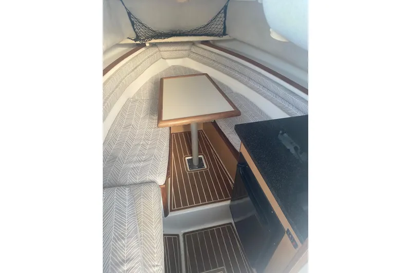 Slide: The Image of Interior of 1994 Robalo 2440 Walkaround boat with seating, table, and kitchenette. - 12