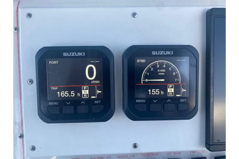 Slide: The Image of Suzuki engine gauges on a 1994 Robalo 2440 Walkaround boat dashboard. - 8