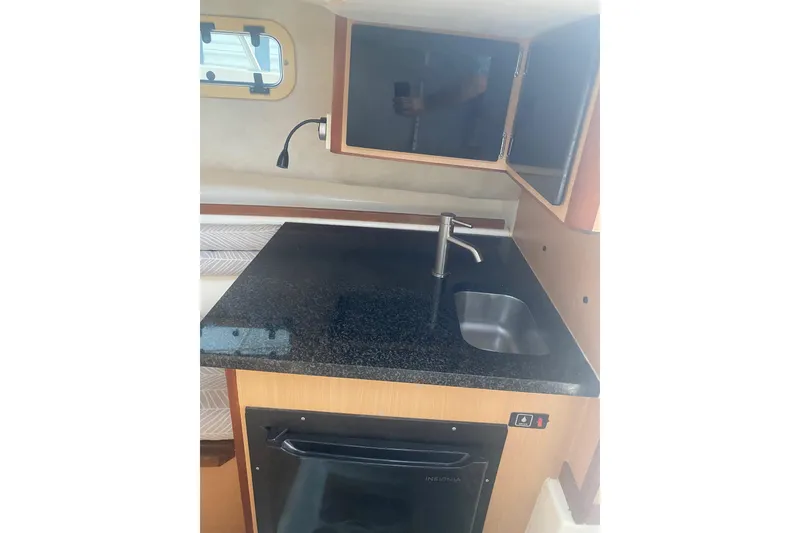 Slide: The Image of Interior of 1994 Robalo 2440 Walkaround boat with kitchenette and sink. - 14