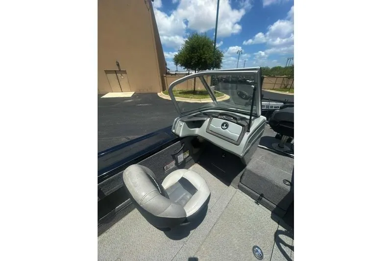 Slide: The Image of 2017 Tracker Targa V-18 WT boat interior with seating and dashboard under blue sky. - 7