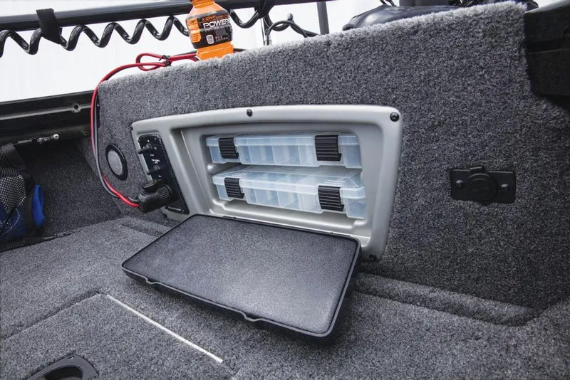 Slide: The Image of The image shows a gray interior of a Tracker Targa V-18 WT boat with built-in storage compartments. - 35