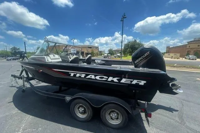 Slide: The Image of 2017 Tracker Targa V-18 WT boat with Mercury engine on trailer, parked outdoors. - 2