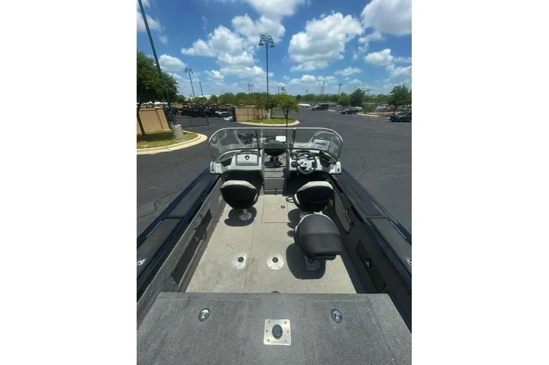 Slide: The Image of 2017 Tracker Targa V-18 WT boat interior with seating and dashboard under blue sky. - 9