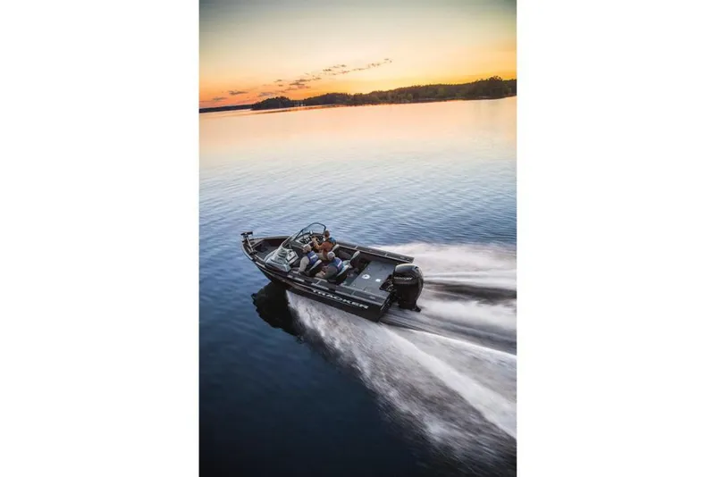 Slide: The Image of A 2017 Tracker Targa V-18 WT boat speeds across calm water at sunset. - 16