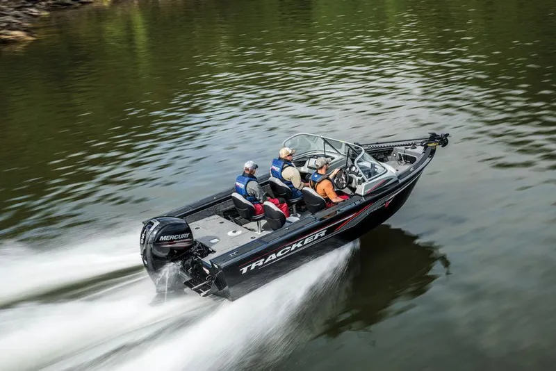 Slide: The Image of A 2017 Tracker Targa V-18 WT boat speeds across the water with four people on board. - 15