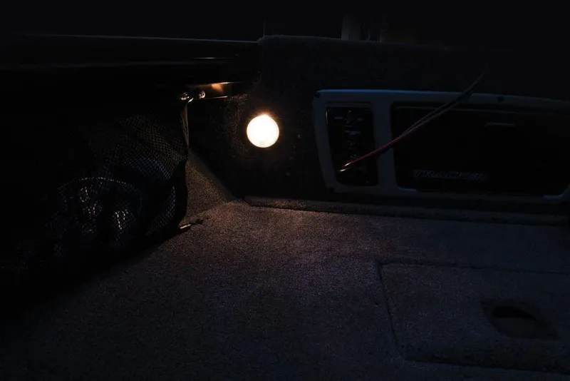 Slide: The Image of A dimly lit boat interior with a small light and a mesh storage compartment. - 44