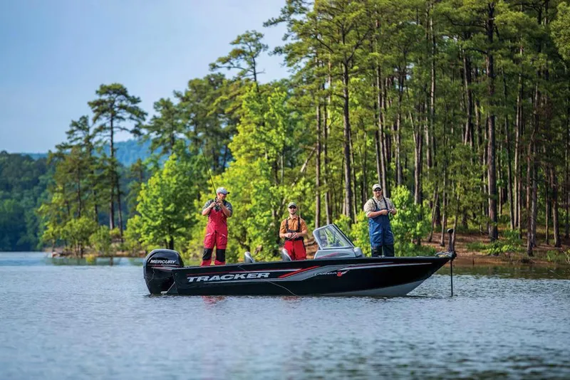 Slide: The Image of Three people fishing on a Tracker Targa V-18 WT boat on a calm lake. - 13