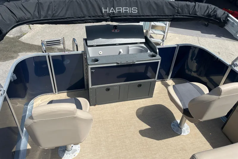 Slide: The Image of 2024 Harris Cruiser 230 boat interior with seating and kitchenette area. - 11