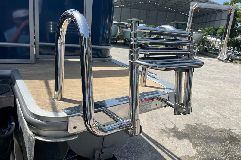 Slide: The Image of Chrome ladder on 2024 Harris Cruiser 230 pontoon boat, docked outdoors. - 9