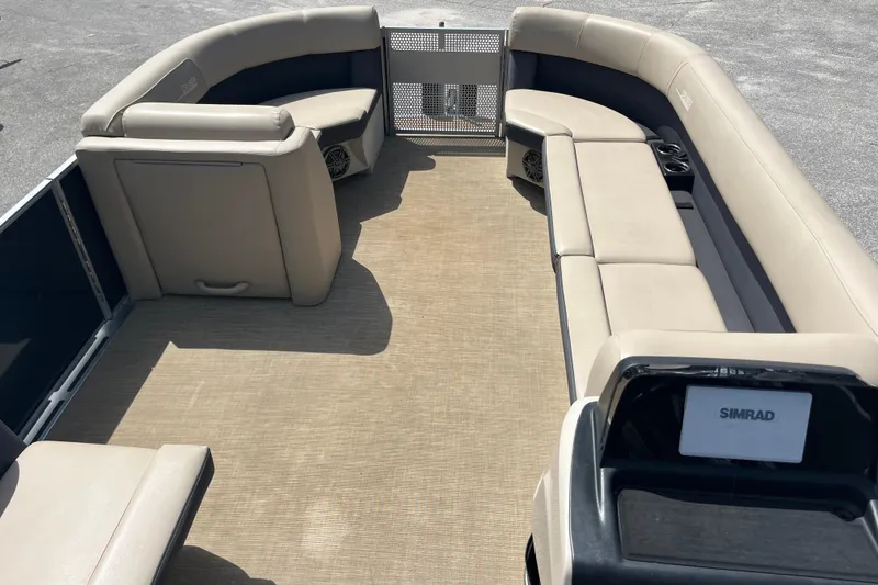 Slide: The Image of 2024 Harris Cruiser 230 pontoon boat interior with beige seating and Simrad navigation system. - 13
