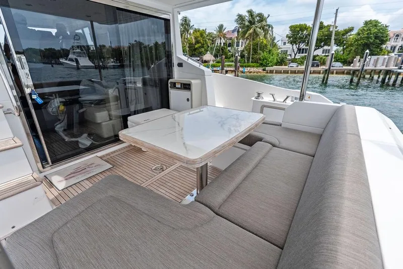 Slide: The Image of Luxurious 2022 Azimut Fly 50 yacht with elegant outdoor seating and scenic waterfront view. - 14