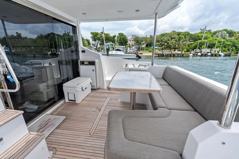 Slide: The Image of Luxurious 2022 Azimut Fly 50 yacht deck with seating, table, and scenic waterfront view. - 13
