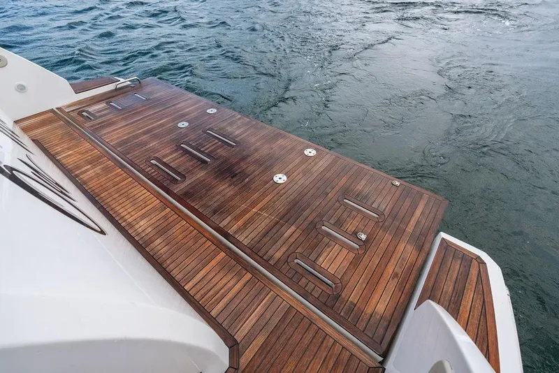 Slide: The Image of Luxury Azimut Fly 50 yacht's teak swim platform, 2022 model, on calm water. - 12