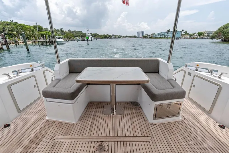 Slide: The Image of Azimut Fly 50 yacht deck with seating and table, cruising on a scenic waterway. - 15