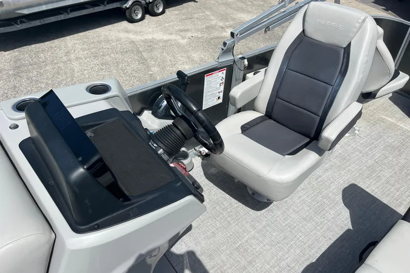 Slide: The Image of 2024 Harris Cruiser 230 boat interior with steering console and comfortable seating. - 10