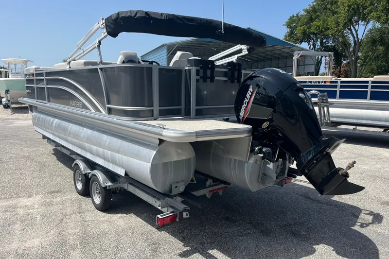 Slide: The Image of 2024 Harris Cruiser 230 pontoon boat with Mercury outboard engine on trailer. - 6