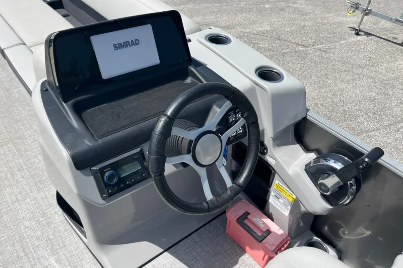 Slide: The Image of 2024 Harris Cruiser 230 boat dashboard with steering wheel and Simrad display. - 11