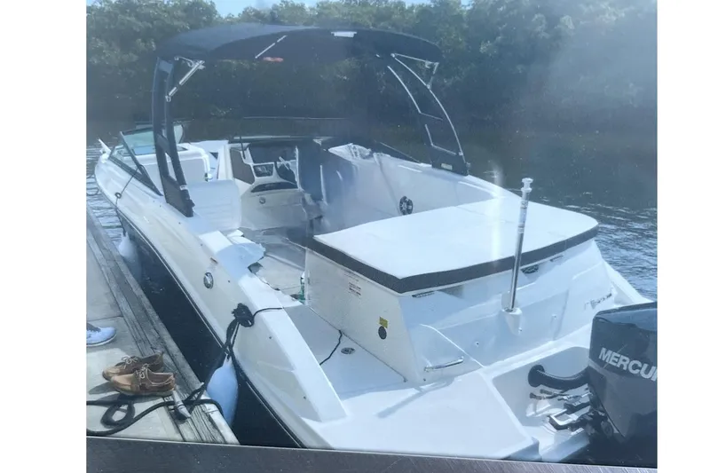 Slide: The Image of A 2020 Sea Ray SPX 230 Outboard docked. It features a black sunshade. - 2