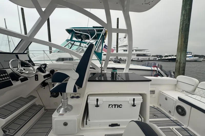 Slide: The Image of 2023 Sea Fox 268 Traveler boat interior with helm, seating, and RTIC cooler at marina. - 33