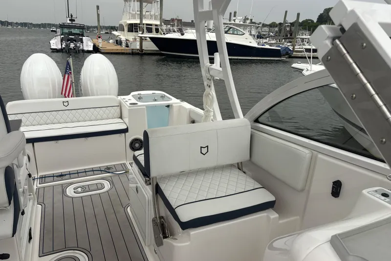 Slide: The Image of 2023 Sea Fox 268 Traveler boat interior with seating and twin engines at a marina. - 29