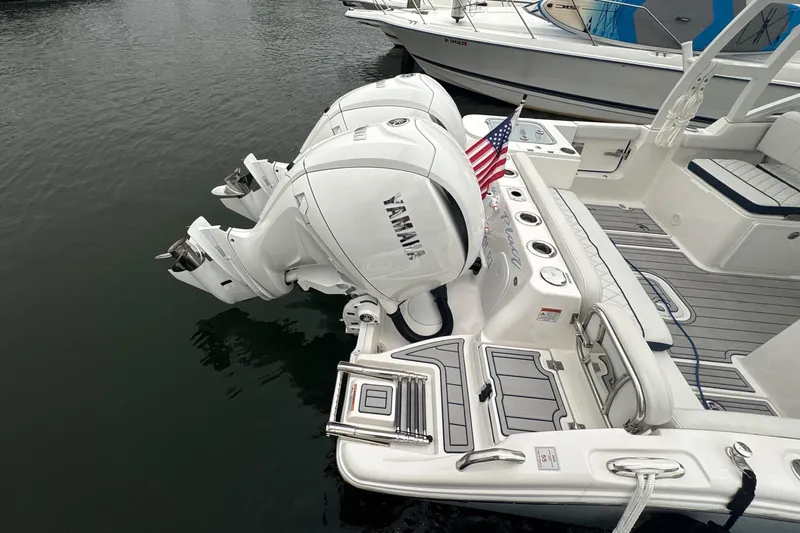 Slide: The Image of 2023 Sea Fox 268 Traveler boat with dual Yamaha engines and American flag at dock. - 58