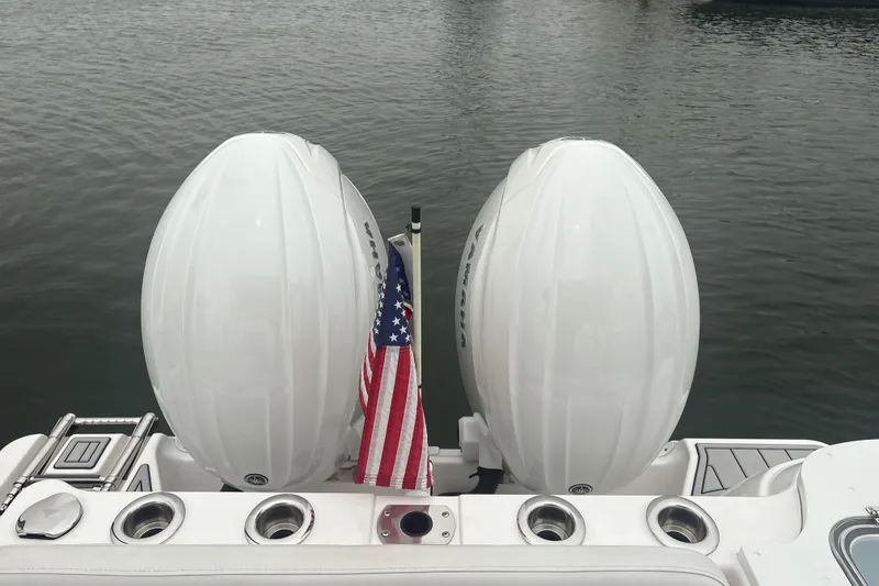 Slide: The Image of 2023 Sea Fox 268 Traveler boat with twin engines and American flag on water. - 57