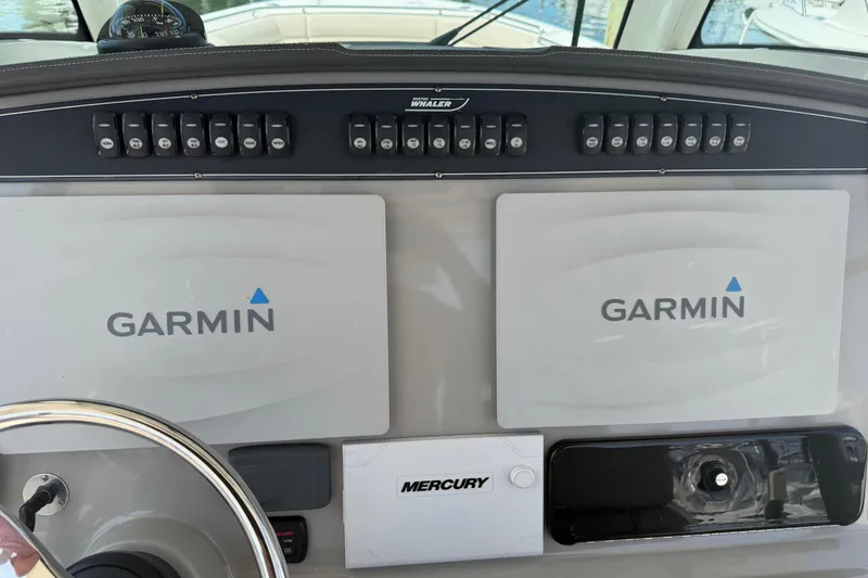Slide: The Image of Control panel of a 2017 Boston Whaler 330 Outrage with Garmin displays and Mercury controls. - 34