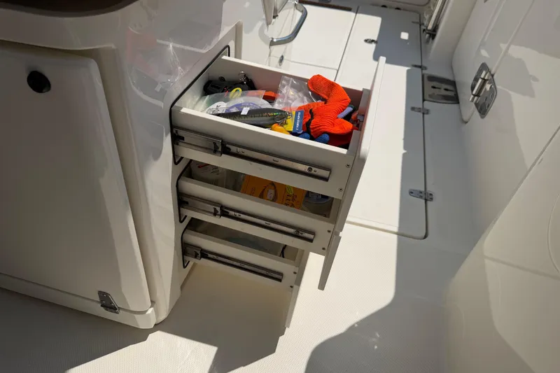 Slide: The Image of Storage drawers on a 2017 Boston Whaler 330 Outrage boat, containing fishing gear and gloves. - 31