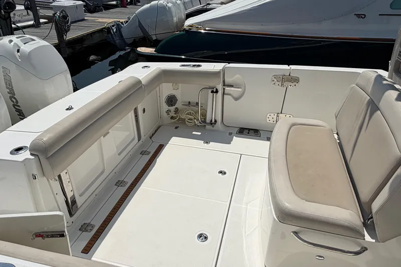 Slide: The Image of 2017 Boston Whaler 330 Outrage boat interior with seating and storage at dock. - 15