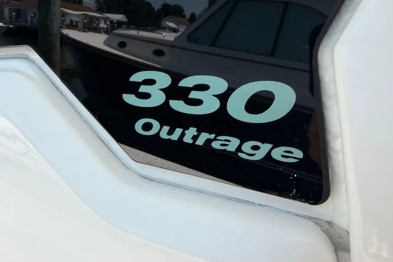 Slide: The Image of Boston Whaler 330 Outrage 2017 boat model nameplate on white hull. - 39