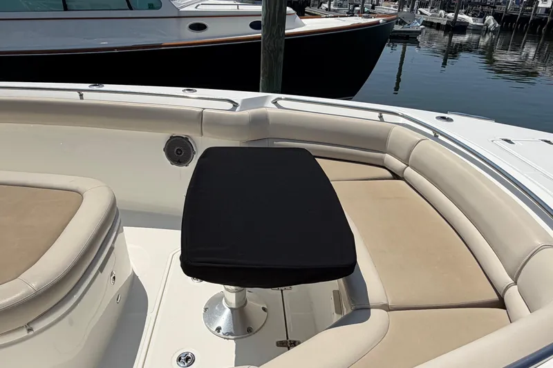 Slide: The Image of 2017 Boston Whaler 330 Outrage boat interior with cushioned seating and table. - 10