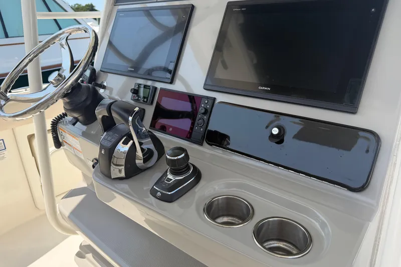 Slide: The Image of Control panel of a 2017 Boston Whaler 330 Outrage with steering wheel and navigation screens. - 38