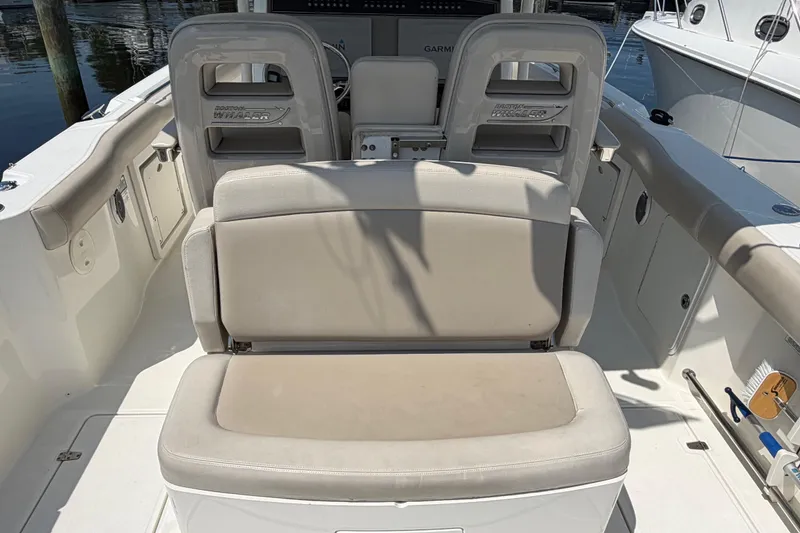 Slide: The Image of 2017 Boston Whaler 330 Outrage boat interior with cushioned seating and helm station. - 22
