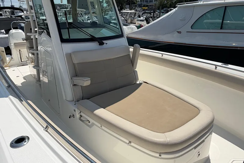 Slide: The Image of 2017 Boston Whaler 330 Outrage boat interior with cushioned seating and helm station. - 11