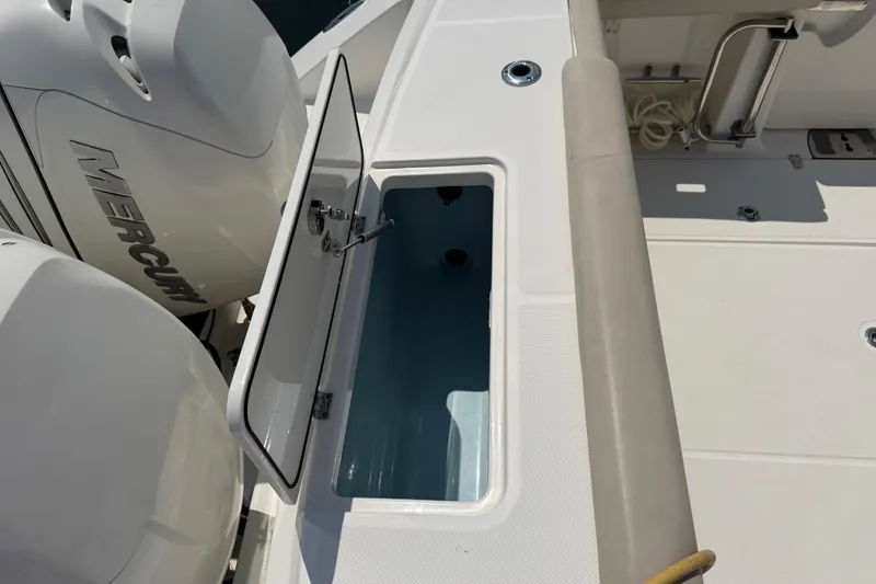 Slide: The Image of 2017 Boston Whaler 330 Outrage boat with open storage compartment and Mercury engines. - 50