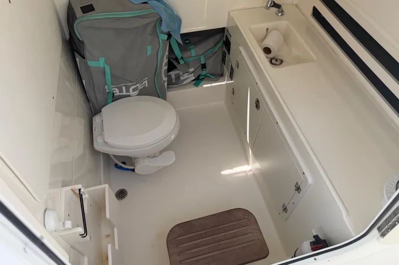 Slide: The Image of 2017 Boston Whaler 330 Outrage boat bathroom with toilet, sink, and storage. - 49