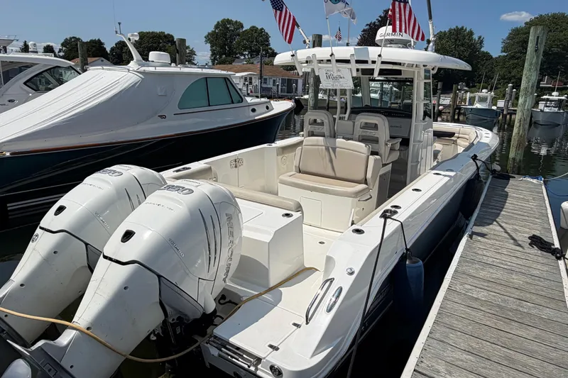 Slide: The Image of 2017 Boston Whaler 330 Outrage docked, featuring dual Mercury engines and spacious seating. - 7