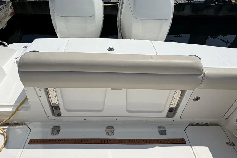 Slide: The Image of 2017 Boston Whaler 330 Outrage boat deck with cushioned seating and dual engines. - 16