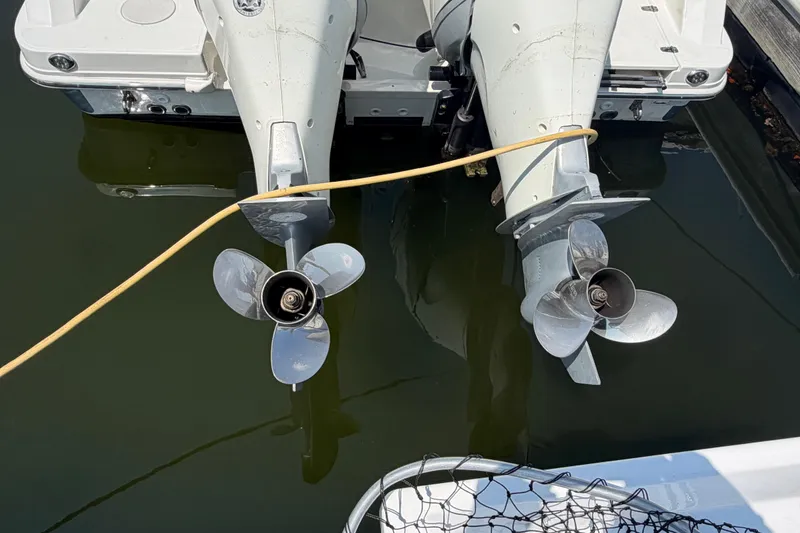 Slide: The Image of Twin outboard motors on a 2017 Boston Whaler 330 Outrage, docked in calm water. - 4