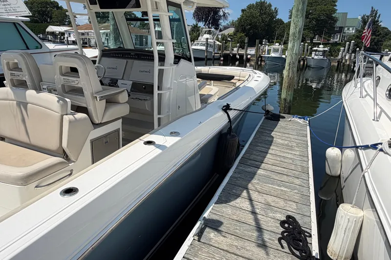 Slide: The Image of 2017 Boston Whaler 330 Outrage docked, showcasing sleek design and comfortable seating. - 8