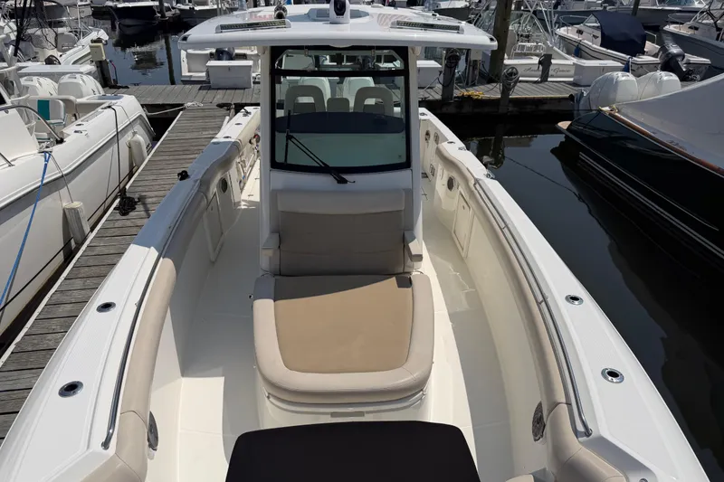Slide: The Image of 2017 Boston Whaler 330 Outrage boat docked at marina, showcasing spacious deck and seating. - 41
