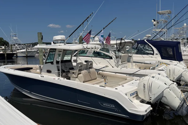 The Image of 2017 Boston Whaler 330 Outrage boat docked at marina with fishing rods and flags. - 0