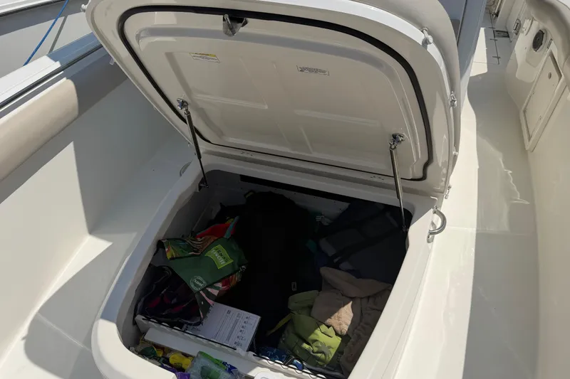 Slide: The Image of Open storage compartment on a 2017 Boston Whaler 330 Outrage boat, containing various items. - 43