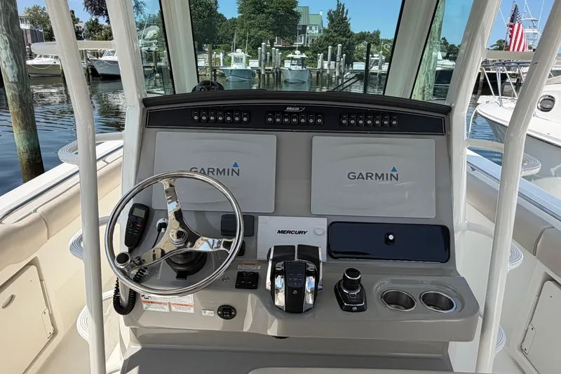Slide: The Image of 2017 Boston Whaler 330 Outrage helm with Garmin displays and Mercury controls at marina. - 25