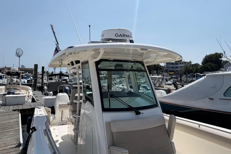 Slide: The Image of 2017 Boston Whaler 330 Outrage docked, featuring Garmin equipment and sleek design. - 12