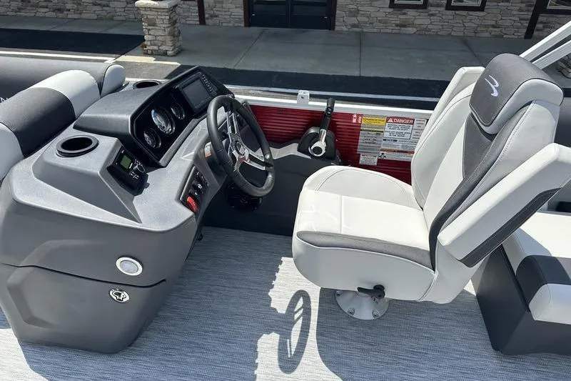 Slide: The Image of 2026 Bennington S Quad Bench 20 SSR boat interior with steering console and captain's chair. - 12