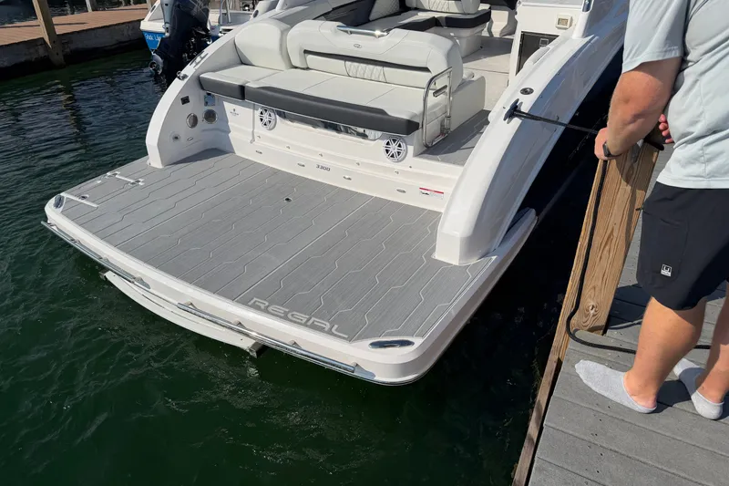 Slide: The Image of 2027 Regal 3300 boat docked, featuring spacious rear deck and seating area. - 16