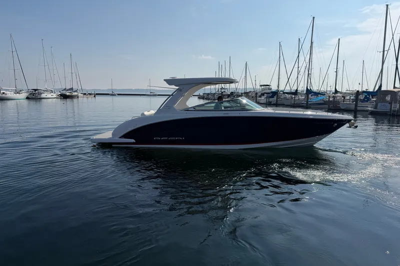 Slide: The Image of 2027 Regal 3300 boat cruising in a marina with sailboats in the background. - 4