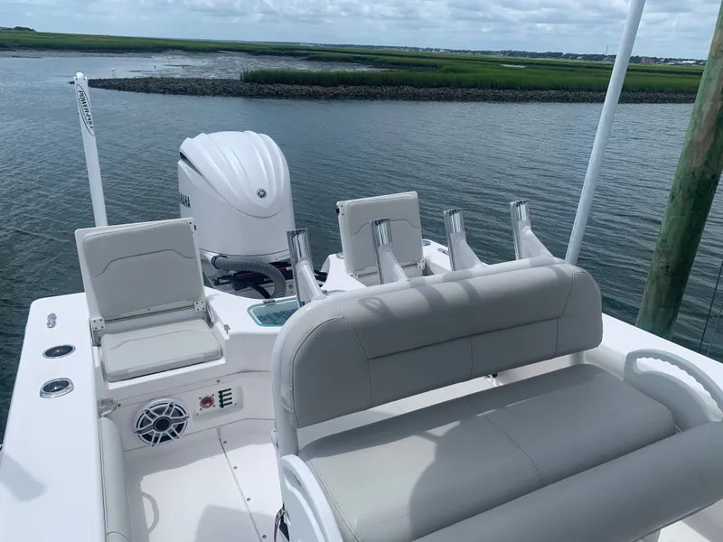 Slide: The Image of The image shows the cockpit of a 2023 Everglades 243 Center Console boat with white seating and an outboard motor. - 16