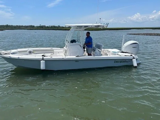 Slide: The Image of A 2023 Everglades 243 Center Console boat on calm water with a person onboard. - 2